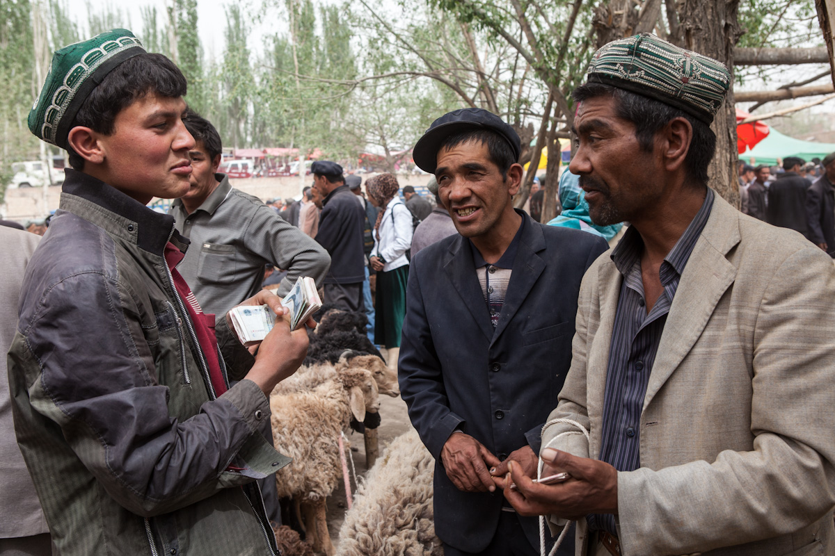 Drei Händler tauschen sich auf dem Viehmarkt in Upal aus. Der Ort liegt entlang des Karakorum-Highway und etwa 50 Kilometer von Kashgar entfernt. Upal - Xinjiang - China