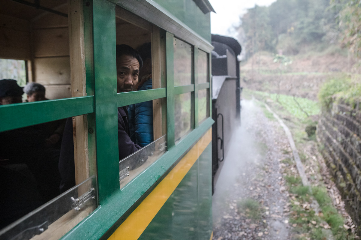 Ein Passagier schaut aus der Zug, der gerade aus einem Tunnel rausfährt. Yuejin Bagou - Sichuan - China
