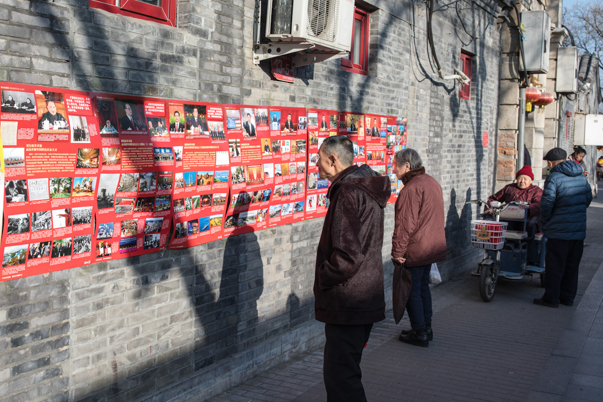 Mehrere Anwohner lesen an einer öffentlichen Wandzeitung, an einer Hauswand in Peking. Anläßlich des 40. Jahrestages der wirtschaftlichen Öffnung Chinas am 18.12.2018, zeigen viele Artikel und Bilder die damalige und aktuelle Entwicklung Chinas. Peking - China