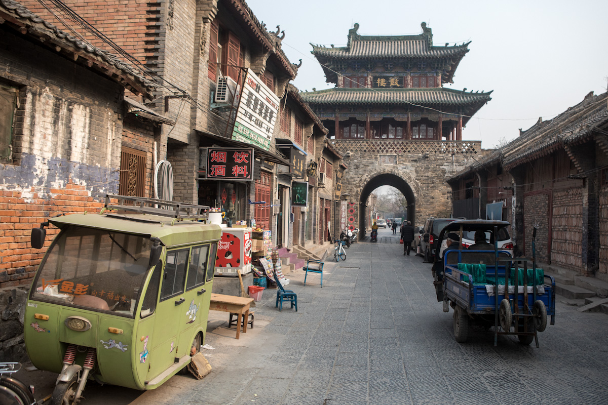 An mehreren kleinen Geschäften vorbei, führt die Straße in Luoyang durch die Altstadt zum Stadttor. Luoyang - Henan - China