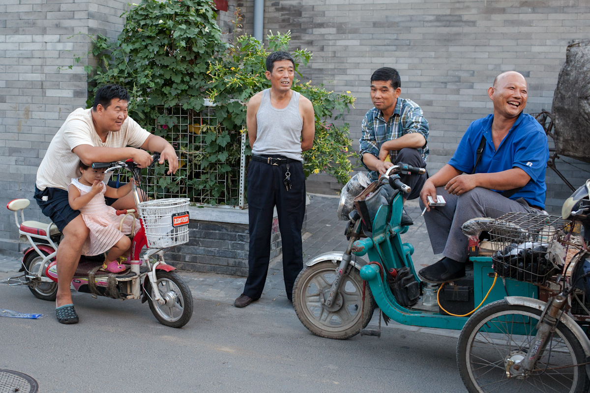 Anwohner eines Hutongs unterhalten sich an einem Sommerabend. Peking - China